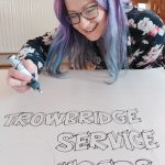 Nicola davis drawing Trowbridge Users Group Logo on to silk
